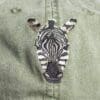 A zebra 's head is embroidered on the back of a hat.