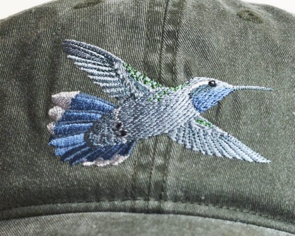 A close up of the back of a hat with a hummingbird on it