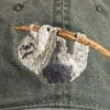 A close up of the back of a hat with a sloth on it