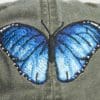A close up of the back of a hat with a butterfly on it