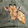 A green hat with a Giraffe embroidered on it.